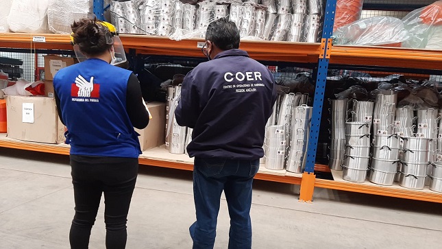 Comisionada de la Defensoría del Pueblo y representante del COER supervisando un almacén.