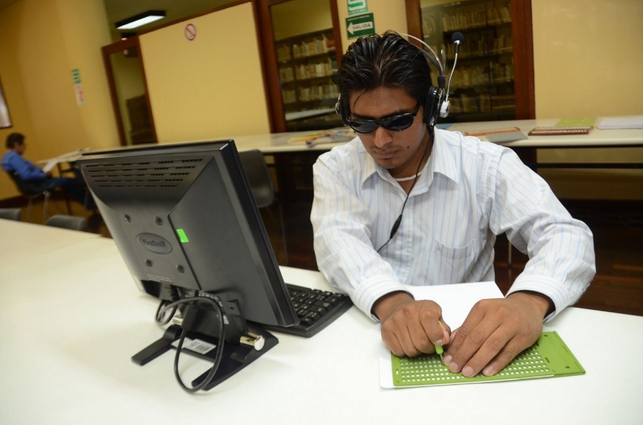 joven con discapacidad visual frente a una computadora