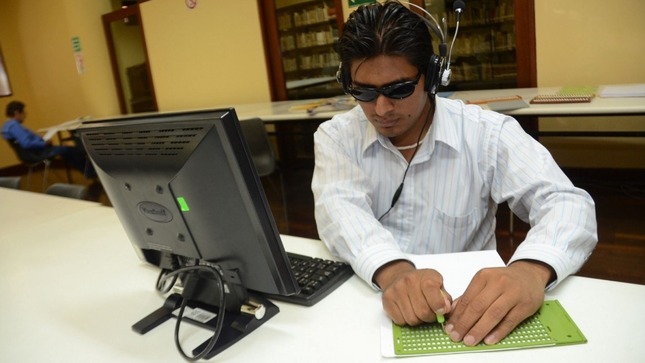 joven con discapacidad visual frente a una computadora