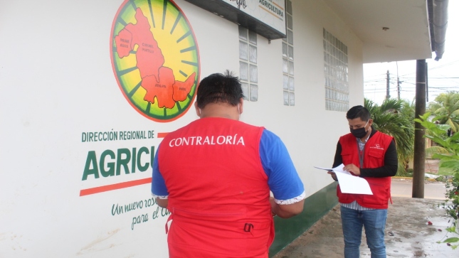 Imagen JPG de dos colaboradores de la Contraloría revisando documentación en los exteriores de la Dirección Regional de Agricultura Ucayali.