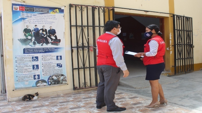 Imagen JPG de dos colaboradores de la Contraloría parados en los exteriores de la Dirección Regional de Salud de Tumbes en el marco de la supervisión de abastecimiento de oxígeno medicinal.