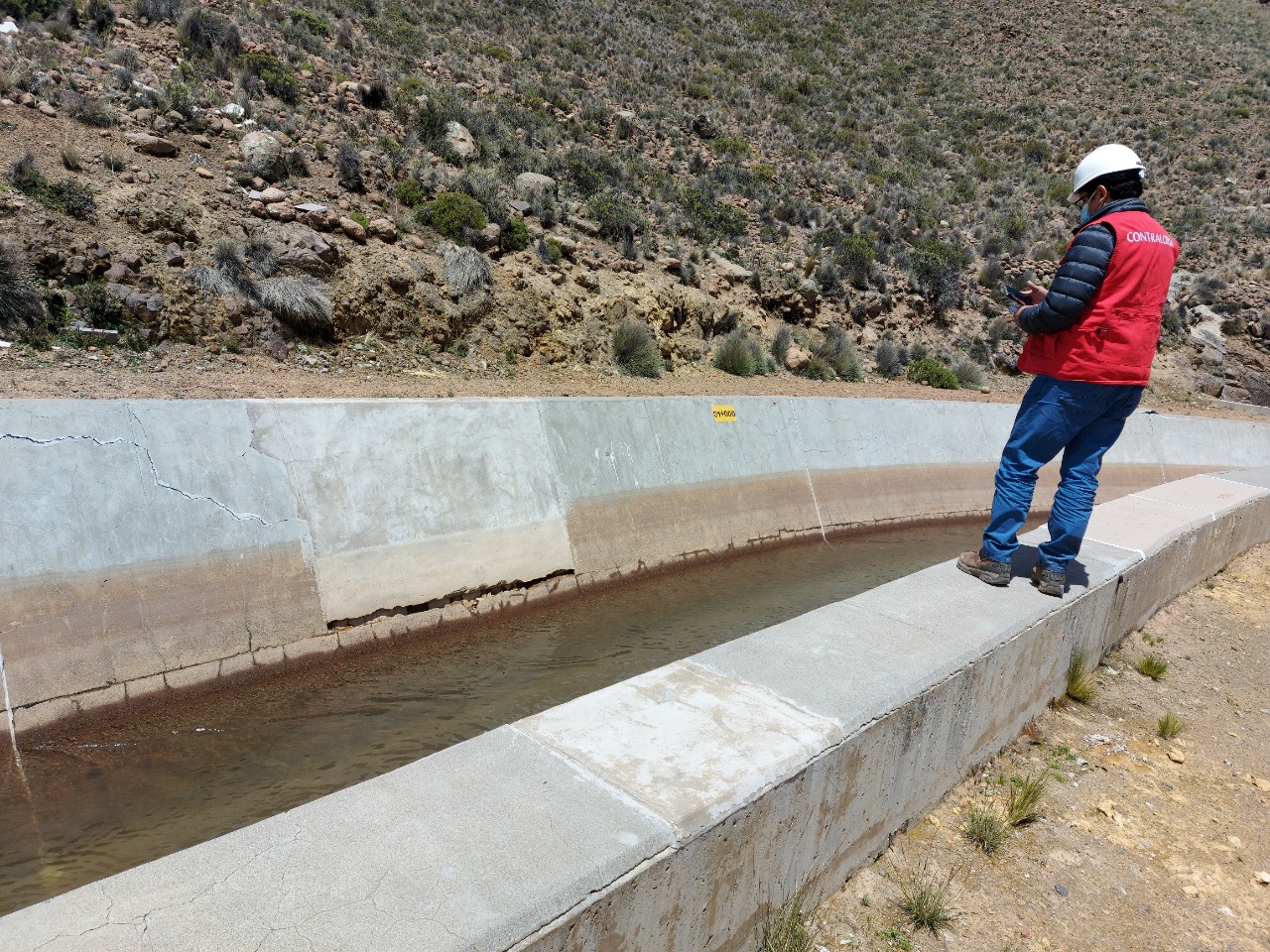 Imagen JPG de colaborador de la Contraloría supervisando canal de Pasto Grande en Moquegua.