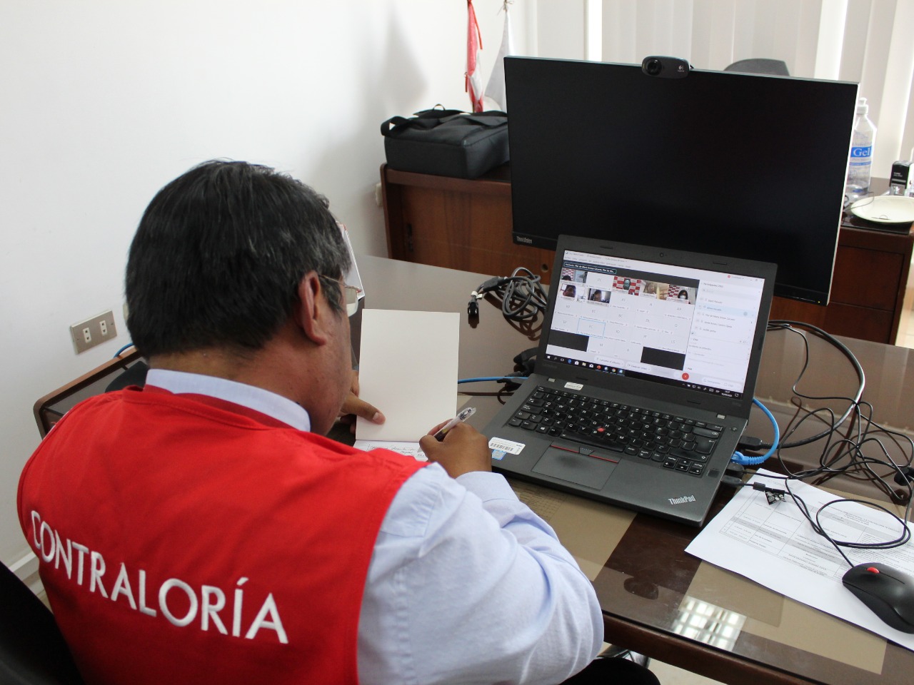 Imagen JPG de colaborador de la Contraloría en los interiores de una oficina, sentado y participando de la Audiencia Pública Virtual “La Contraloría te escucha” en Madre de Dios.