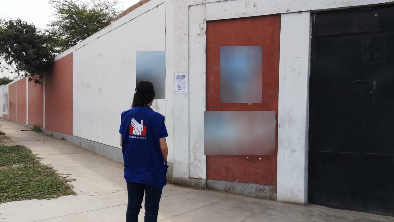 Comisionada supervisando propaganda electoral en centro de votación.