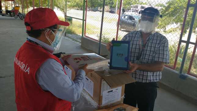 Imagen JPG de colaboradores de la Contraloría supervisando entrega de tablets a escolares y docentes en Piura.