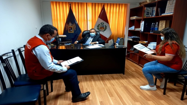Imagen JPG de colaboradores de la Contraloría supervisando entrega de tablets a escolares y docentes en Áncash en el interior de una oficina.