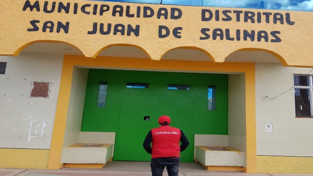 Imagen JPG colaborador de la Contraloría observando la puerta principal de la Municipalidad Distrital de Salinas en Puno.