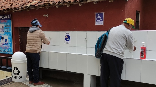 Foto de dos personas lavándose las manos en el lavadero