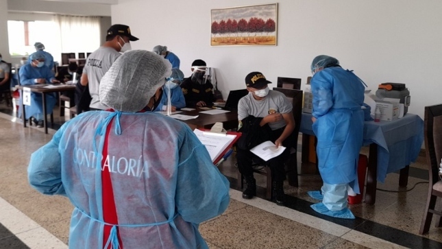 Imagen JPG de colaboradores de la Contraloría supervisando vacunación contra la Covid-19 a policías en retiro en Arequipa. 
