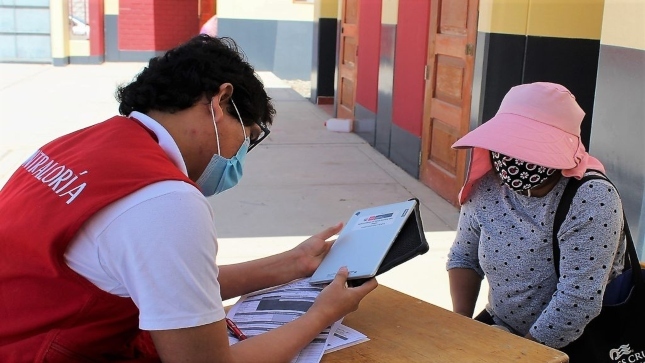 Imagen JPG de colaborador de la Contraloría supervisando entrega de tablets Tacna junto a madre de familia.