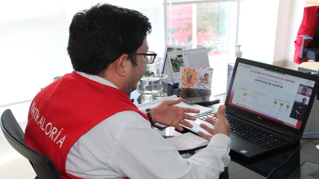 Imagen JPG de colaborador de la Contraloría sentado en una silla en el interior de una oficina y participando desde su laptop en la Audiencia Pública virtual “La Contraloría te escucha” Ucayali.