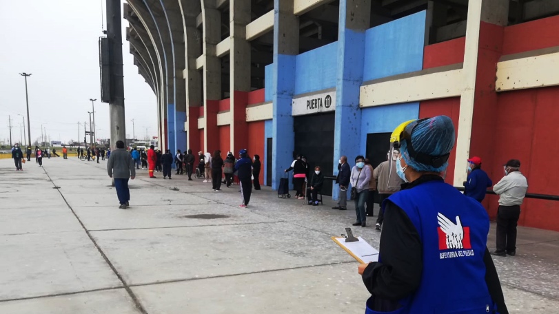Foto de personas haciendo fila para vacunarse