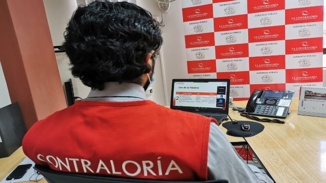 Imagen JPG de colaborador de la Contraloría sentado en su oficina participando en la Audiencia Pública Virtual “La Contraloría te escucha” Ayacucho a través de su laptop. 