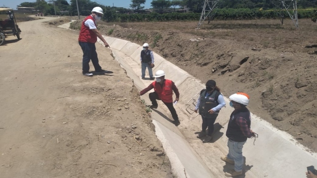Imagen JPG de dos colaboradores de la Contraloría junto a otras tres personas supervisando obra para riego en canal Reque, Cajamarca.