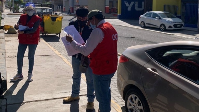 Imagen JPG de dos colaboradores de la Contraloría junta a otra persona revisando papales sobre obra peatonal en Arequipa.