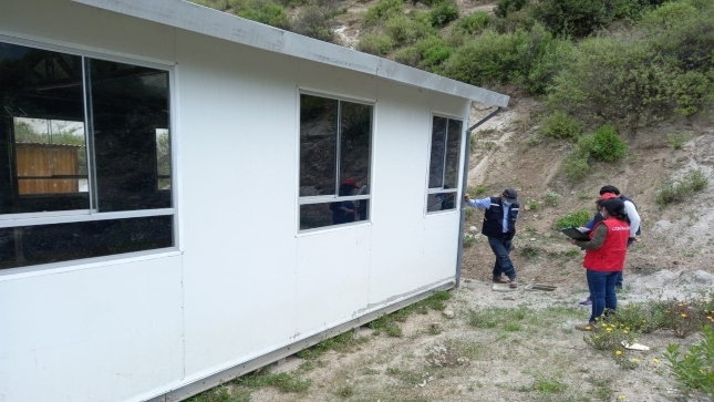 Imagen JPG de colaboradora de la Contraloría supervisando contrato para instalar aulas en comunidad campesina.