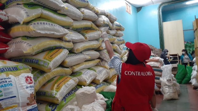 Imagen JPG de colaboradora de la Contraloría supervisando compra de productos sin registro sanitario para canastas de víveres en Pasco.