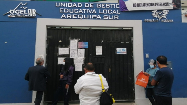 Imagen JPG de varias personas en la puerta y parte de la fachada de la Unidad de Gestión Educativa Local (UGEL) Arequipa – Sur.