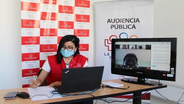 Imagen JPG de colaboradora de la Contraloría sentada en su escritorio, revisando información y participando en Audiencia Pública Virtual “La Contraloría te escucha” Moquegua.