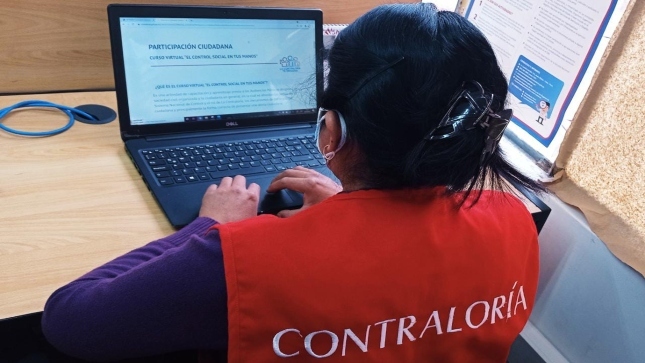 Imagen JPG de colaboradora de la Contraloría revisando información en su computadora sobre curso virtual “El control social en tus manos” Puno.