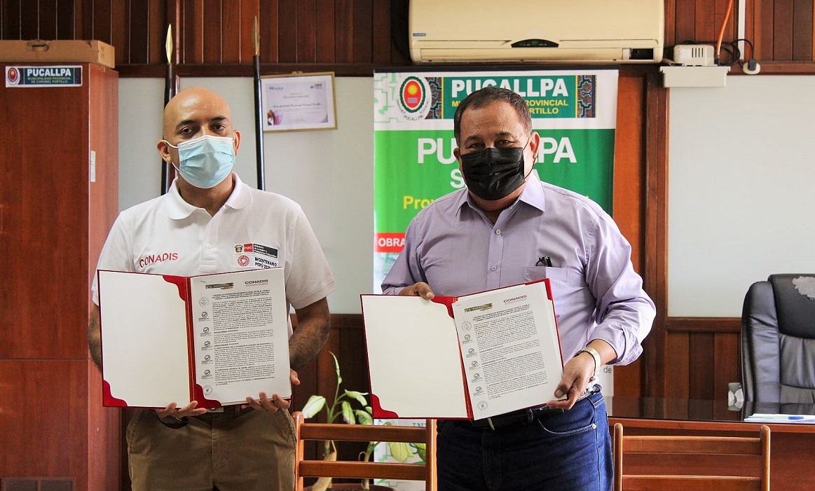 El presidente del Conadis, Marco Antonio Gamarra La Barrera y el alcalde de la provincia de Coronel Portillo, Segundo Pérez Collazos muestran el convenio firmado