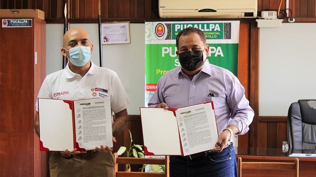 El presidente del Conadis, Marco Antonio Gamarra La Barrera y el alcalde de la provincia de Coronel Portillo, Segundo Pérez Collazos muestran el convenio firmado