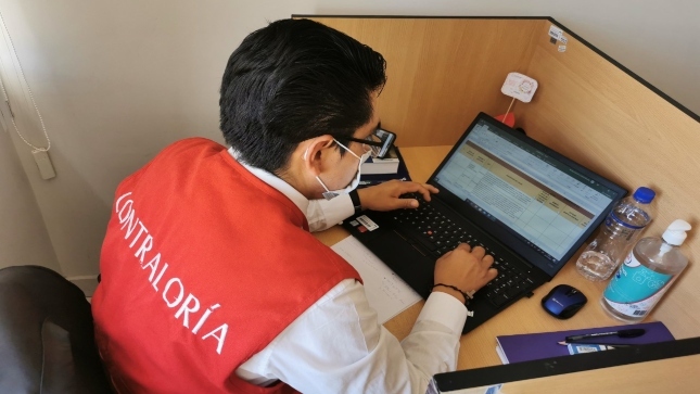 Imagen JPG de colaboradores de la Contraloría sentado revisando en su escritorio revisando información sobre el curso virtual “El control social en tus manos” San Martín.