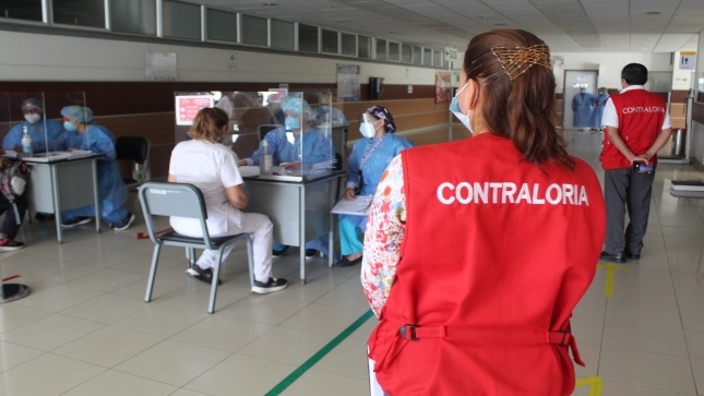 Imagen JPG de colaboradora de la Contraloría observando como personal de vacuna realiza la vacunación contra la COVID-19 en Lambayeque.
