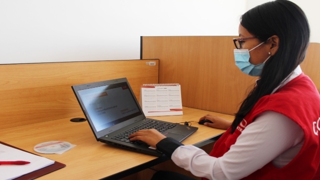 Imagen JPG de colaboradora de la Contraloría sentada en su escritorio con su laptop revisando información del curso virtual en Piura.