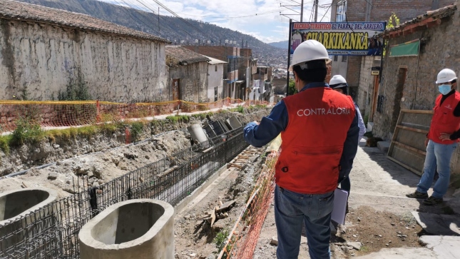 Imagen JPG de tres colaboradores de la Contraloría supervisando obra de drenaje pluvial de Carmen Alto en Ayacucho.
