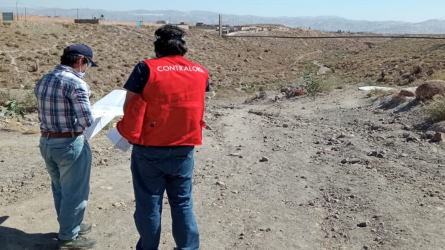 Imagen JPG de colaborador de la Contraloría supervisando obra de saneamiento junto a otra persona en Arequipa.