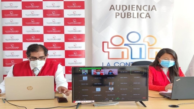 Imagen JPG de dos colaboradores de la Contraloría sentados en su escritorio con sus laptops