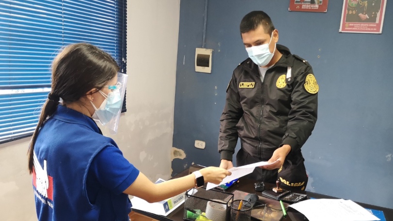 Foto de comisionada de la Defensoría del Pueblo conversando con un policía