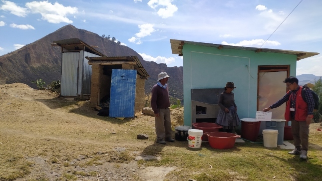 Imagen JPG de colaborador de la Contraloría supervisando que dos ciudadanos están juntando agua el tinas y baldes.
