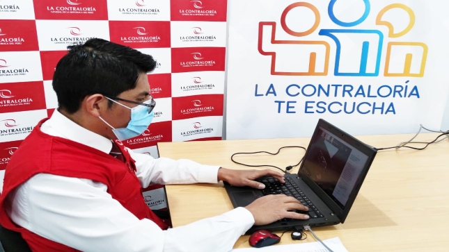 Imagen JPG de colaborador de la Contraloría sentado en su escritorio con su laptop participando en la audiencia pública virtual denominada “La Contraloría te escucha” en Cusco