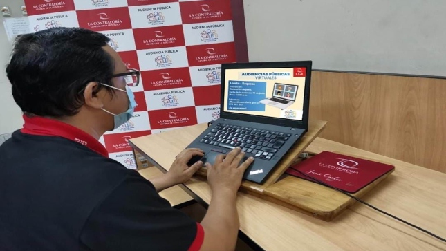 Imagen JPG de colaborador de la Contraloría sentado en su escritorio mirando información en su laptop sobre la audiencia pública virtual denominada “La Contraloría te escucha” en la provincia de Requena, Loreto.