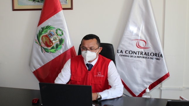 Imagen JPG de colaborador de la Contraloría sentado en su escritorio y trabajando en su laptop.