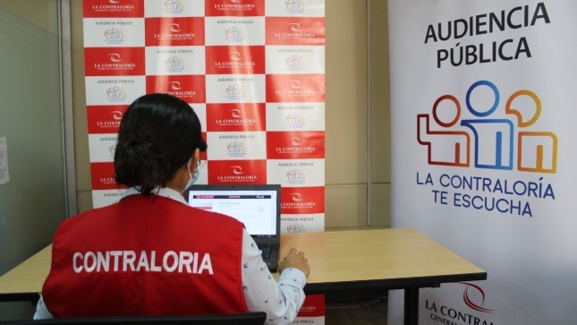 Colaboradora de la Contraloría sentada en un escritorio participando de la Audiencia Pública virtual Lambayeque.