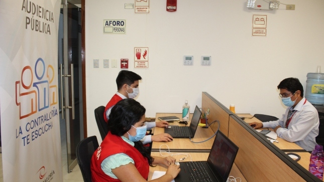 Imagen JPG de colaboradores de la Contraloría sentados en su escritorio trabajando
