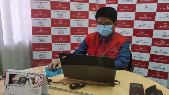 Imagen JPG de colaborador de la Contraloría sentado en su escritorio con su laptop participando de la audiencia pública virtual “La Contraloría te escucha” en Loreto.
