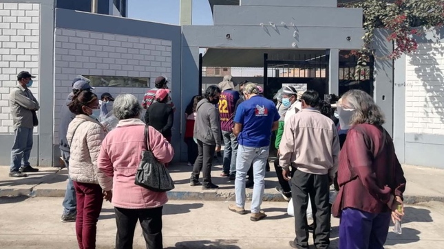 Foto de personas adultas mayores en exterior de local de vacunación