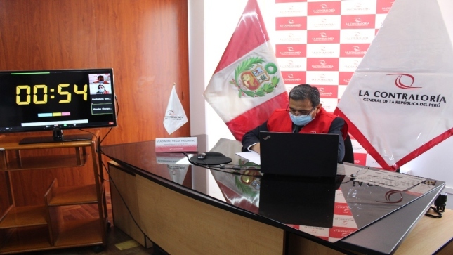 Imagen JPG del colaborador de la Contraloría sentado en su escritorio revisando unos papeles y participando de la Audiencia Pública virtual Chucuito, Puno.
