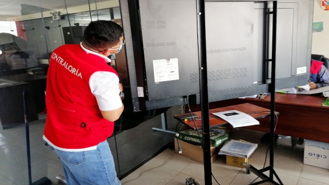 Imagen JPG de colaborador de la Contraloría supervisando pantallas interactivas para colegios en Moquegua.