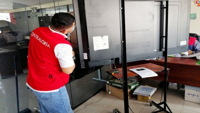Imagen JPG de colaborador de la Contraloría supervisando pantallas interactivas para colegios en Moquegua.