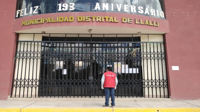 Imagen JPG de colaborador de la Contraloría mirando la puerta de ingreso de la Municipalidad Distrital de Llalli en Puno.
