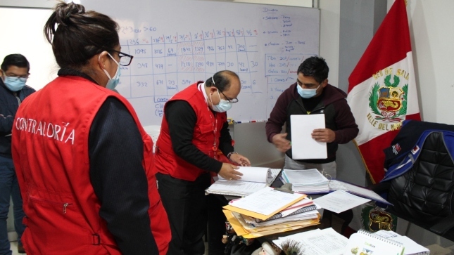 Imagen JPG de colaboradores de la Contraloría revisando unos papeles junto a otras personas de otra institución de la Red de Salud Valle del Mantaro, en la ciudad de Huancayo.