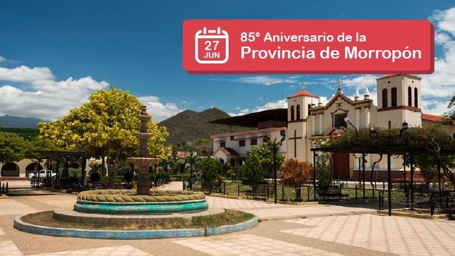 Fotografía de la cuidad plaza de armas de Morropon-Chulucanas, donde hay una pileta, una iglesia con muchos arboles, y tiene un texto que dice 27 de junio 85° Aniversario de la provincia de Morropon.