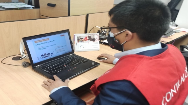 Imagen JPG de colaborador de la Contraloría sentado en su escritorio con su laptop participando del  curso virtual “El control social en tus manos” en Huancavelica.