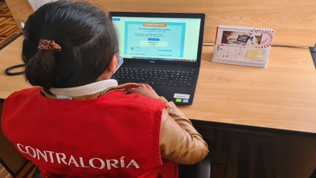 Imagen JPG de colaboradora de la Contraloría sentada en su escritorio participando del curso virtual "El control social en tus manos" en Puno.