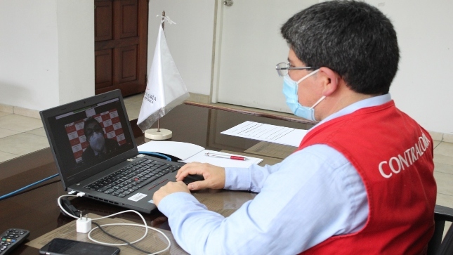 Imagen JPG de colaborador de la Contraloría sentados en su escritorio participando de la Audiencia Pública virtual La Libertad.